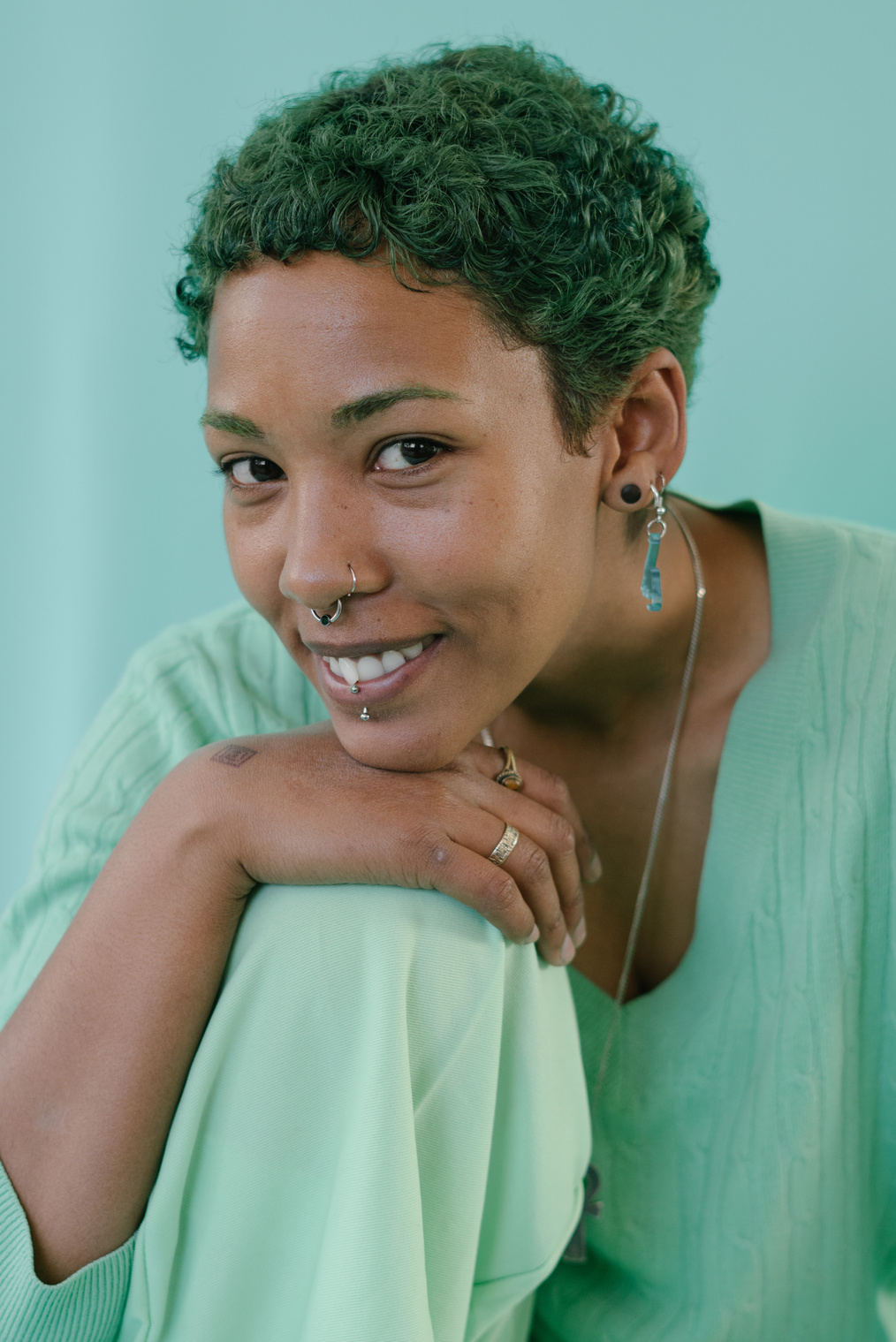 Smiling with Green Hair and Piercings on Nose, Lips, Ears